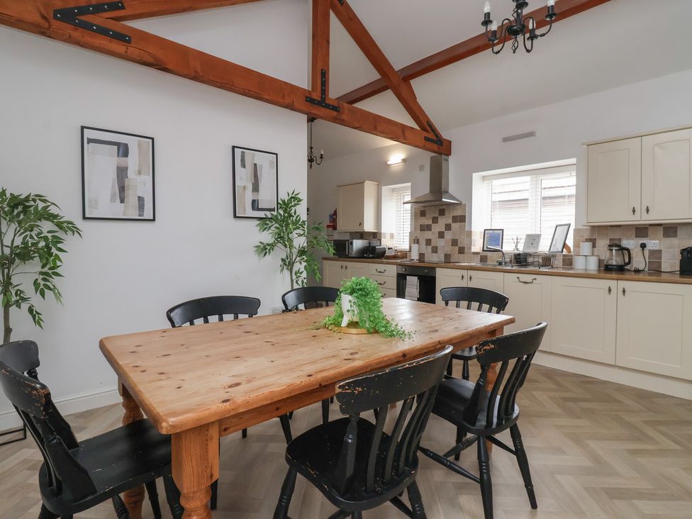 A dining room with a wooden table and chairs at Puffin in Flamborough