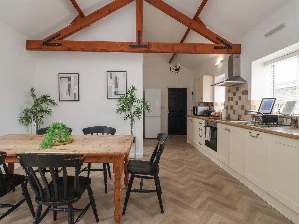 A kitchen with a dining table and chairs at Puffin in Flamborough