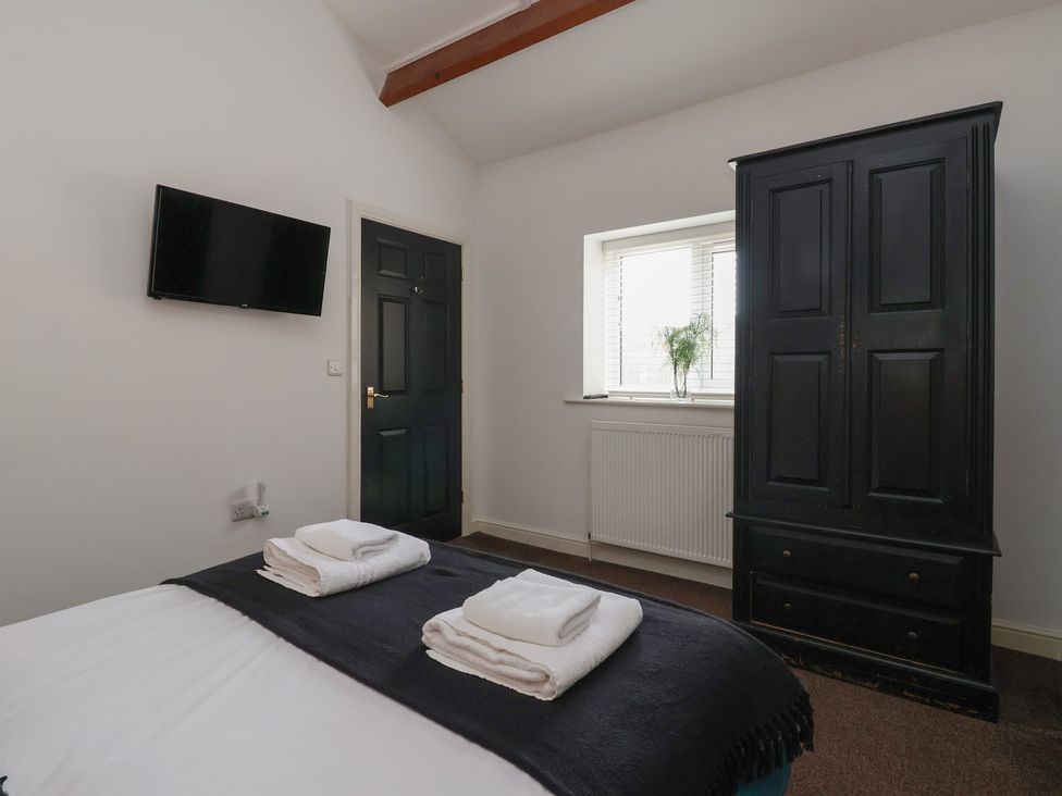 A bedroom with a bed and television at Puffin in Flamborough