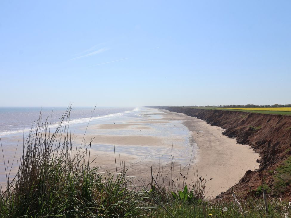A view of a beach and cliff with grass in the foreground at Puffin in Flamborough