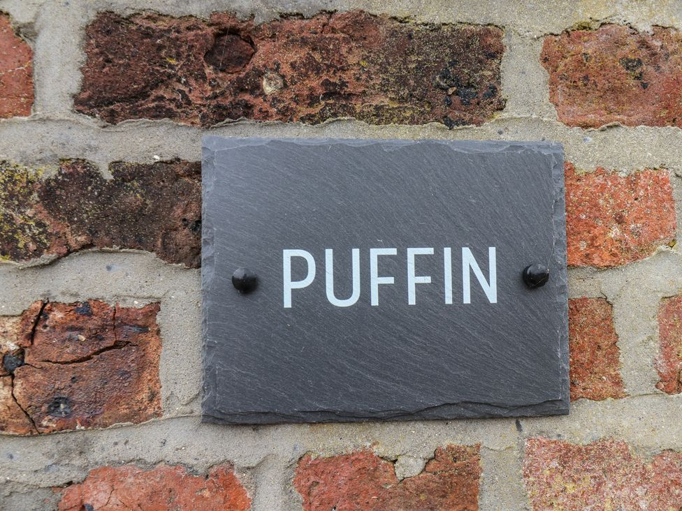 A slate sign with the text PUFFIN on a brick wall at Puffin in Flamborough