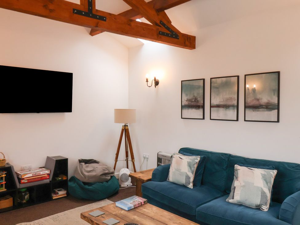 A living room with a sofa, coffee table, and television at Puffin in Flamborough