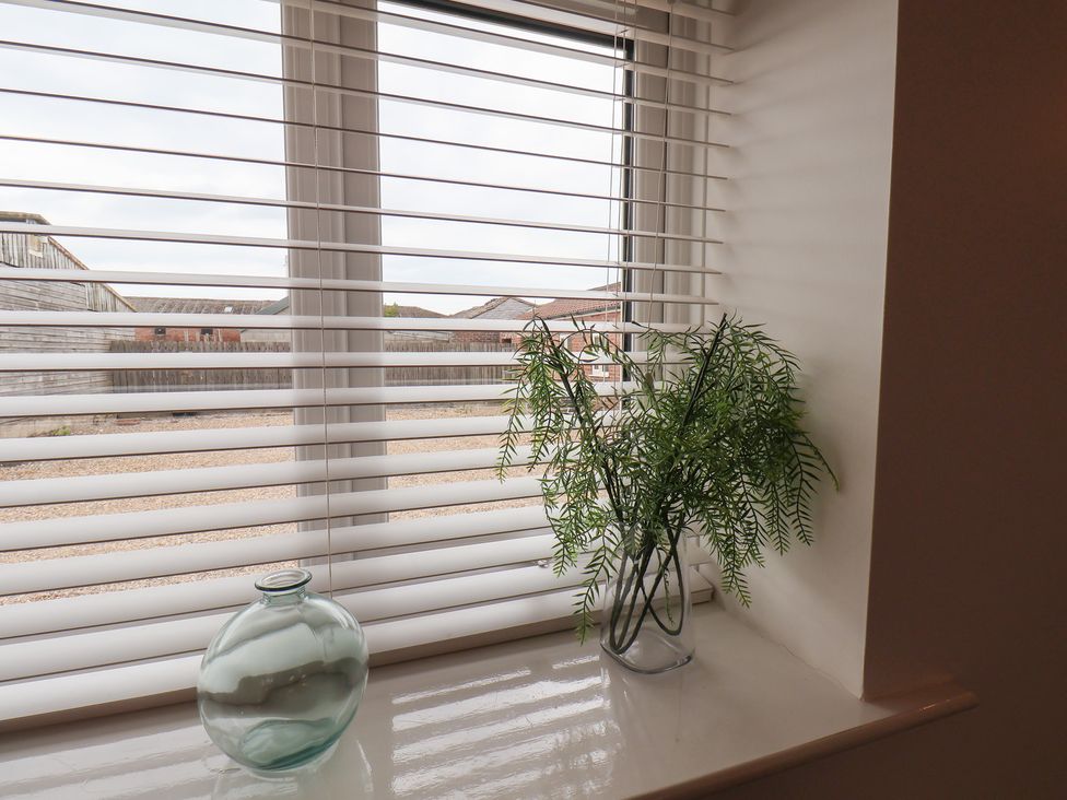 A window with plant and glass vase at Puffin in Flamborough