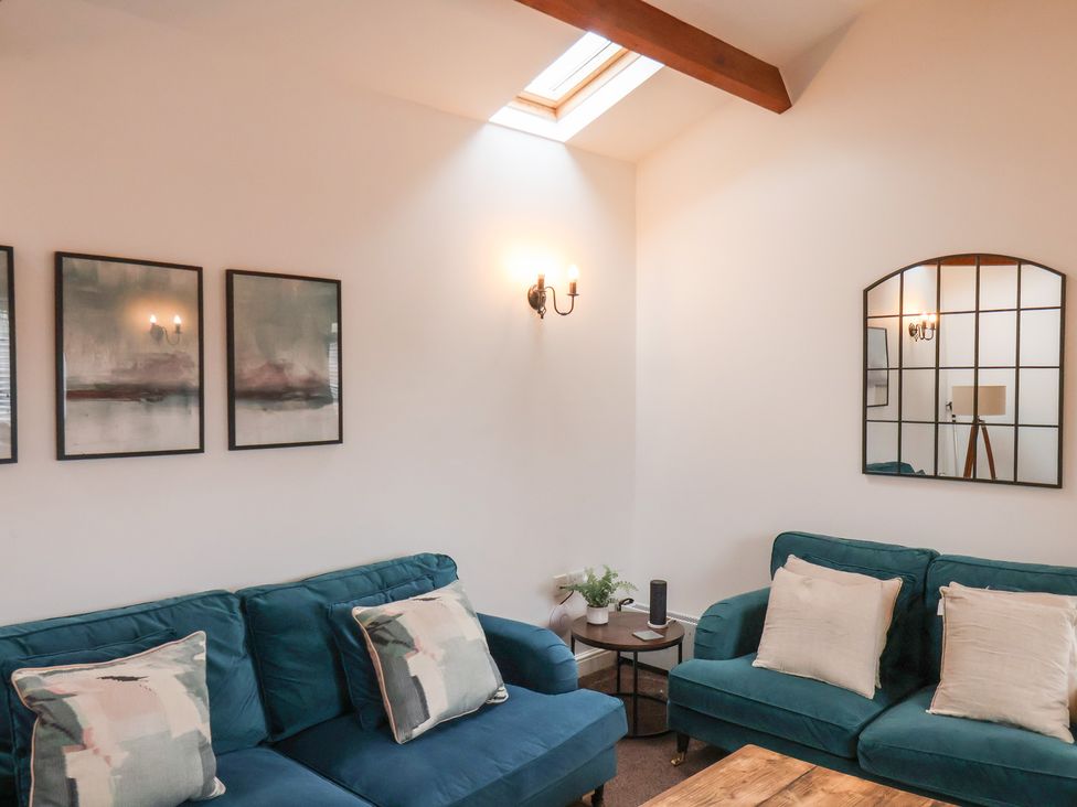 A living room with a sofa and wall art at Puffin in Flamborough