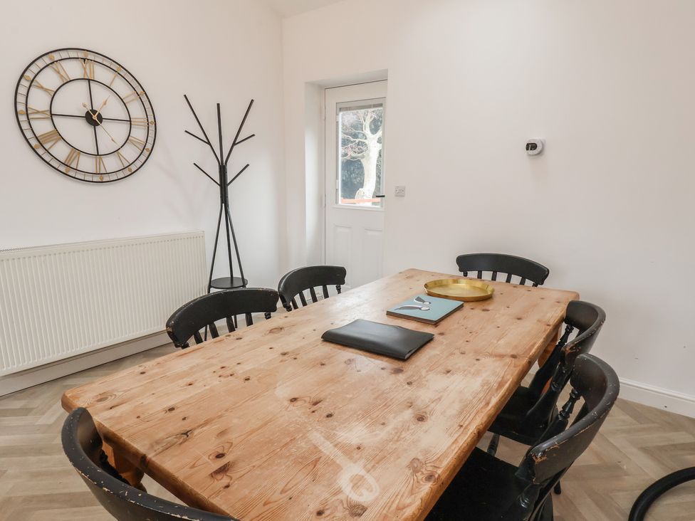 A dining room with a wooden table and chairs at Puffin in Flamborough