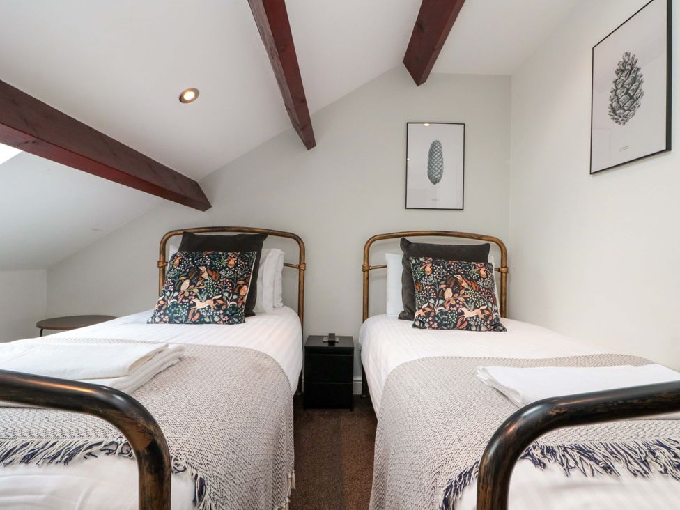 A bedroom with two single beds and artwork at Kittiwake in Flamborough