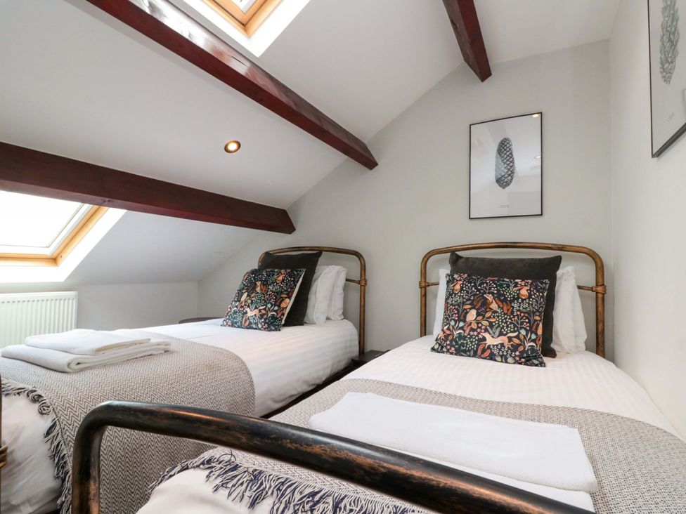 A bedroom with two beds and a skylight at Kittiwake in Flamborough