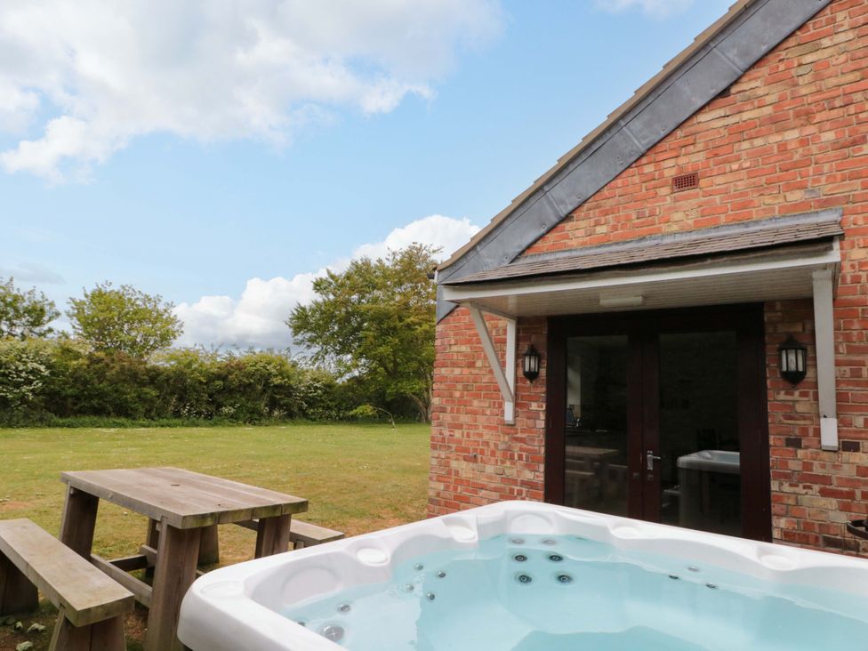 A garden with a hot tub and picnic table at Kittiwake in Flamborough