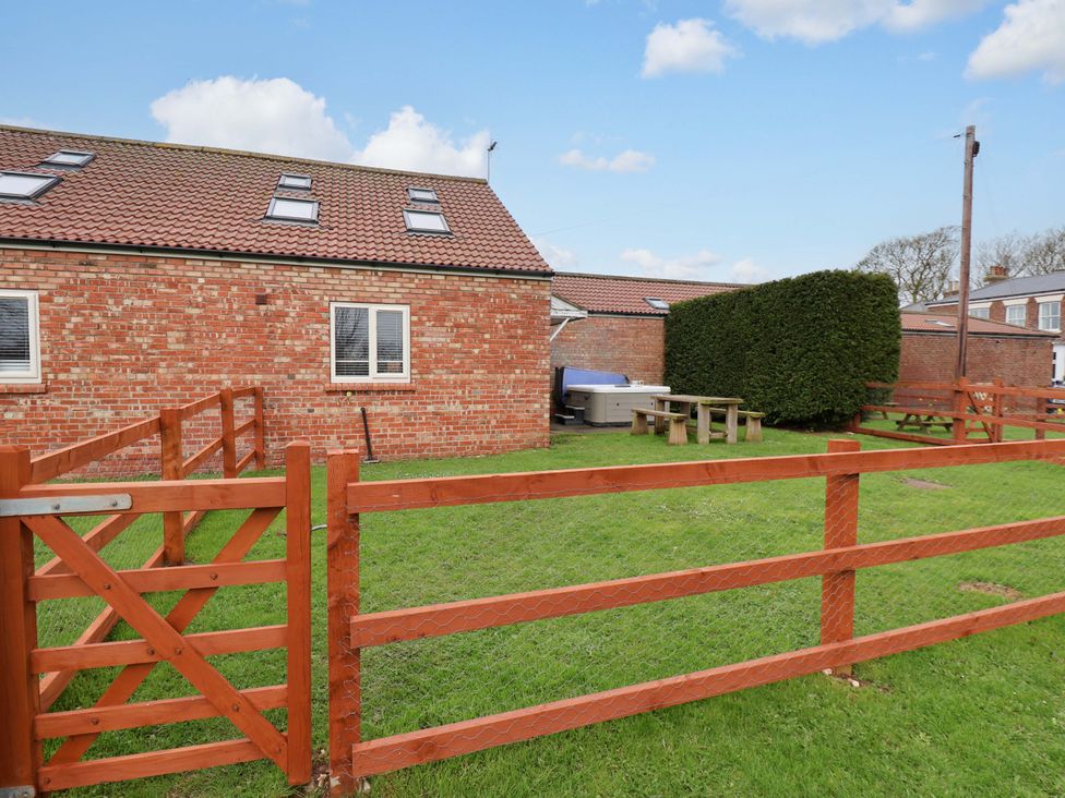 A garden with a fence and table at Kittiwake in Flamborough