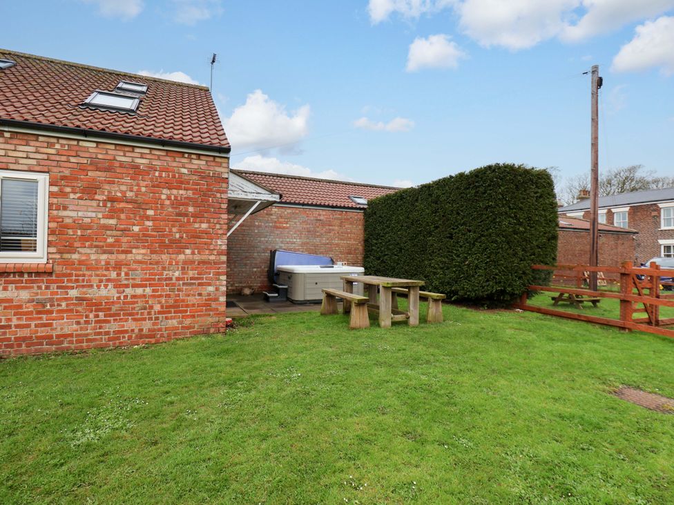 A garden with a hot tub and a picnic table at Kittiwake Flamborough