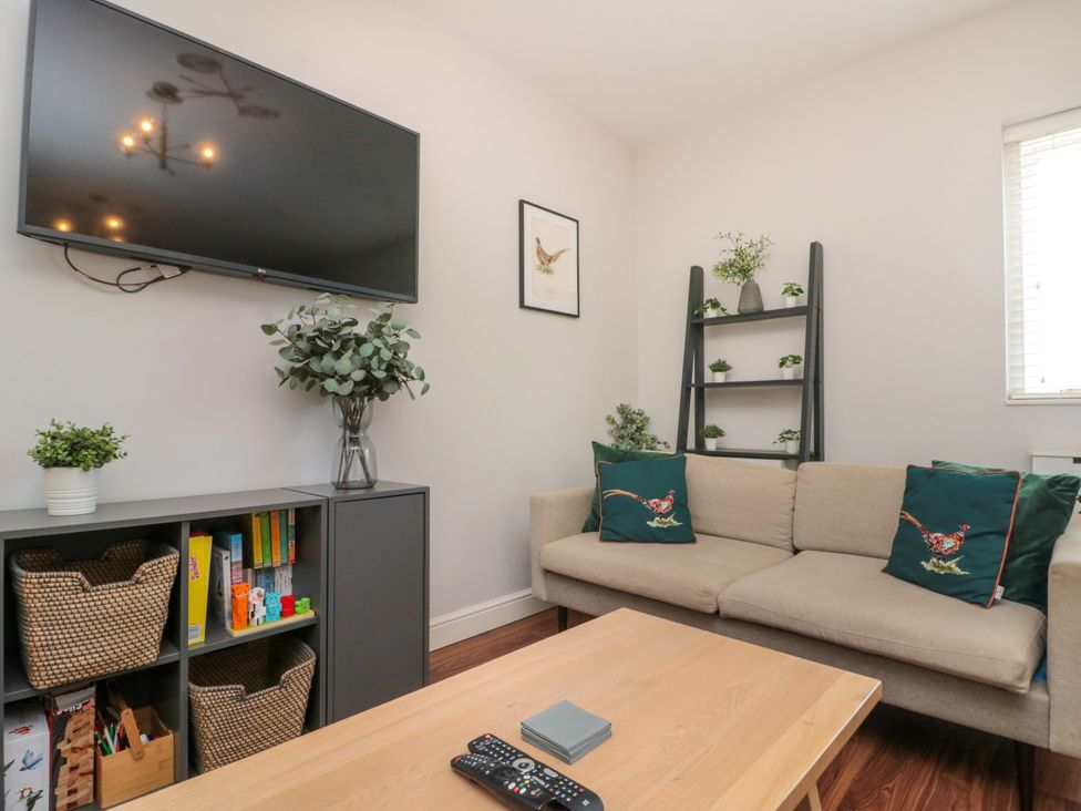 A living room with a sofa and television at The Pheasantry in Flamborough