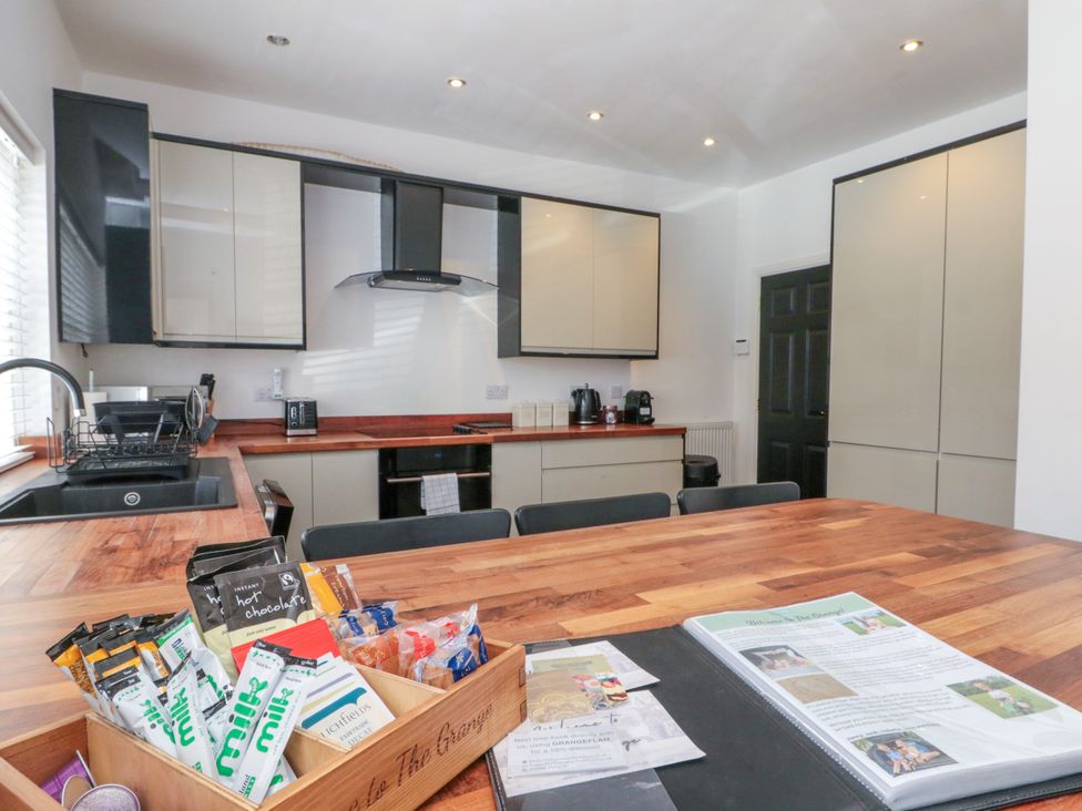 A kitchen with cabinets and a dining table at The Pheasantry in Flamborough