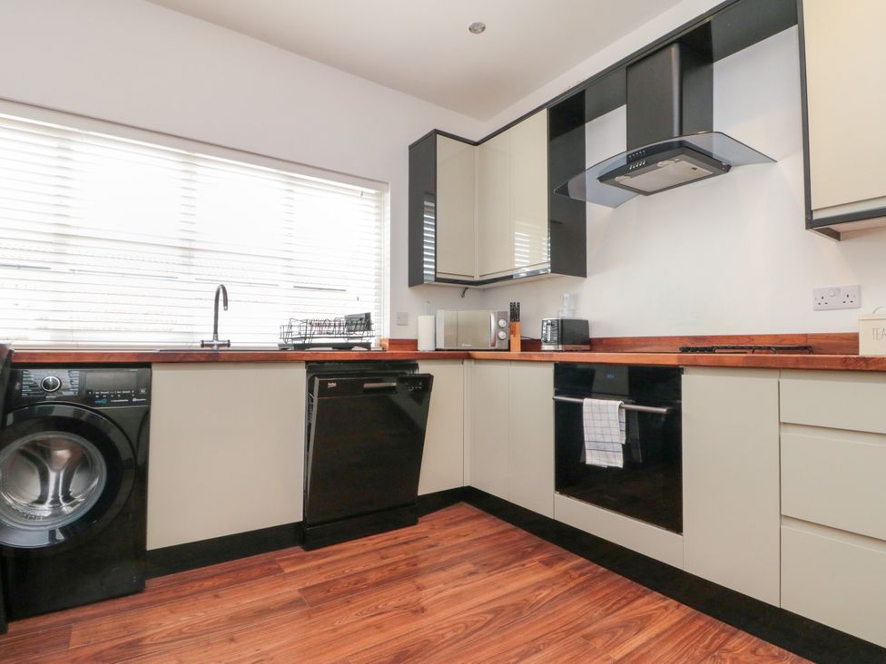 A kitchen with appliances including a washing machine and dishwasher at The Pheasantry in Flamborough
