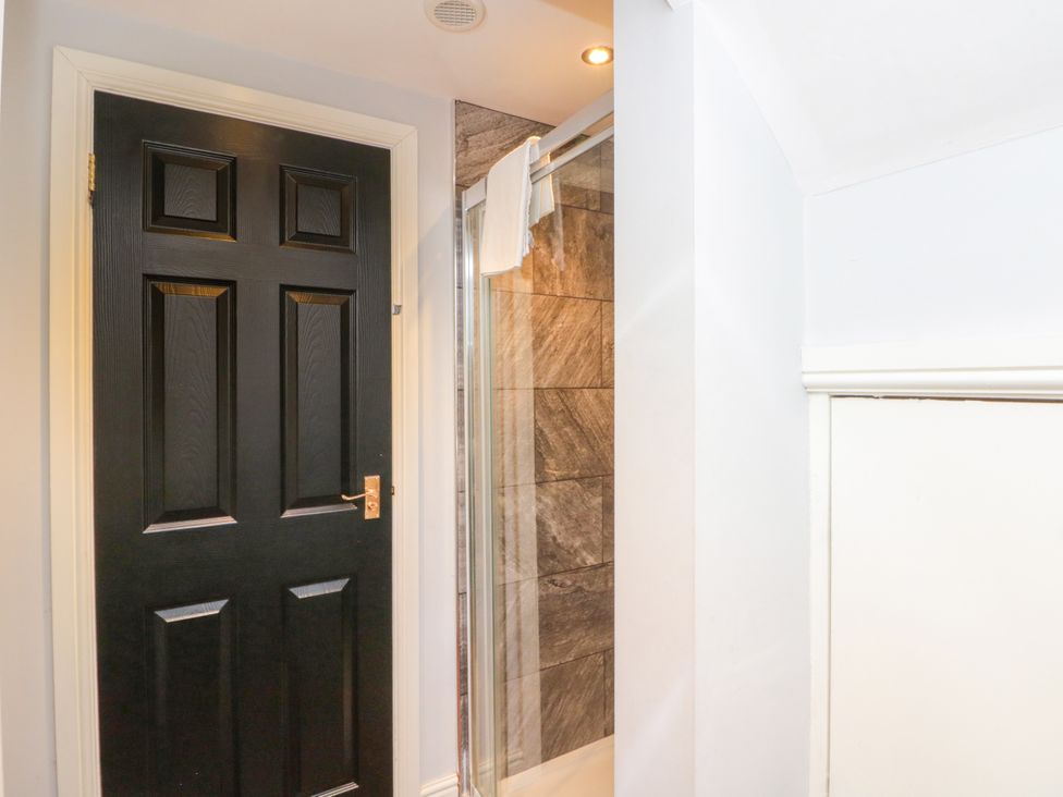 A bathroom with a black door and a shower at The Pheasantry in Flamborough