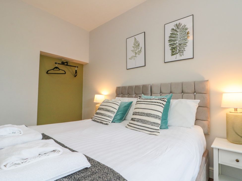 A bedroom with a bed and wall art at The Pheasantry in Flamborough