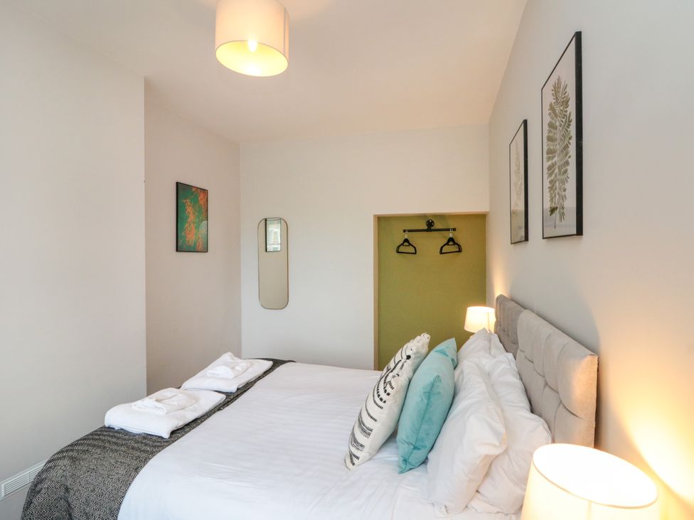 A bedroom with a double bed and mirror at The Pheasantry in Flamborough
