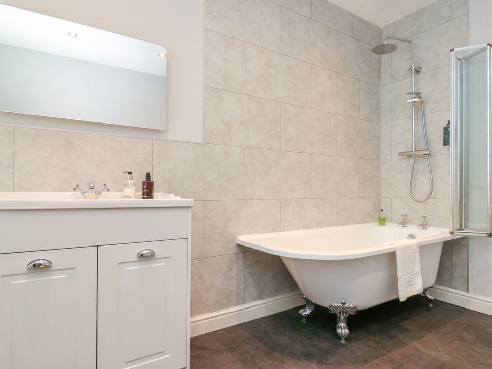 A bathroom with a bathtub and sink at The Pheasantry in Flamborough