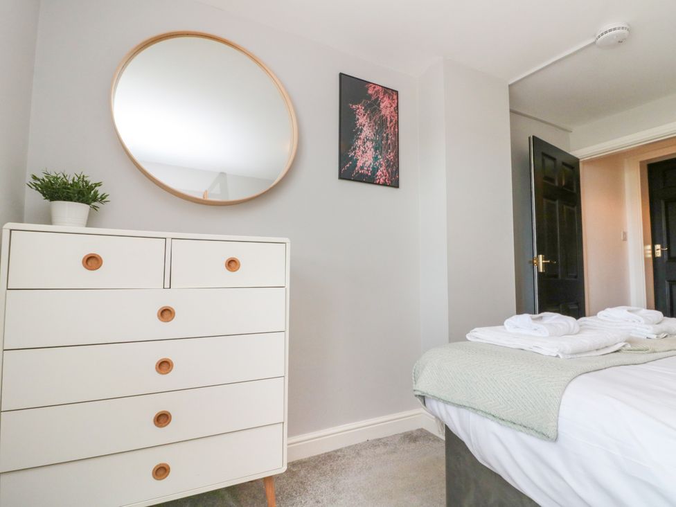 A bedroom with a dresser and mirror at The Pheasantry in Flamborough