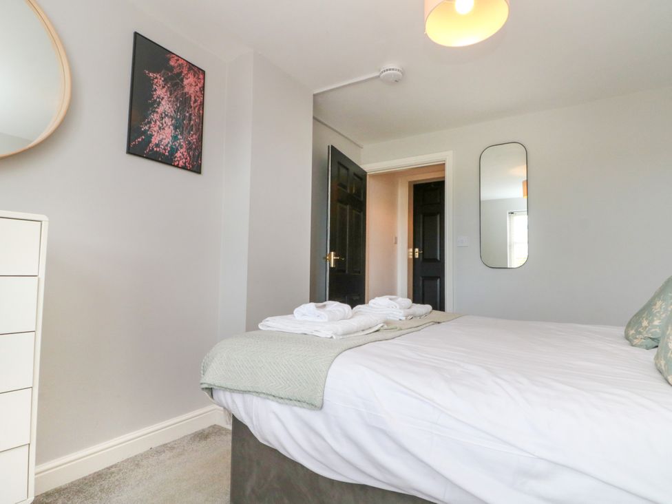 A bedroom with a bed and a mirror at The Pheasantry in Flamborough