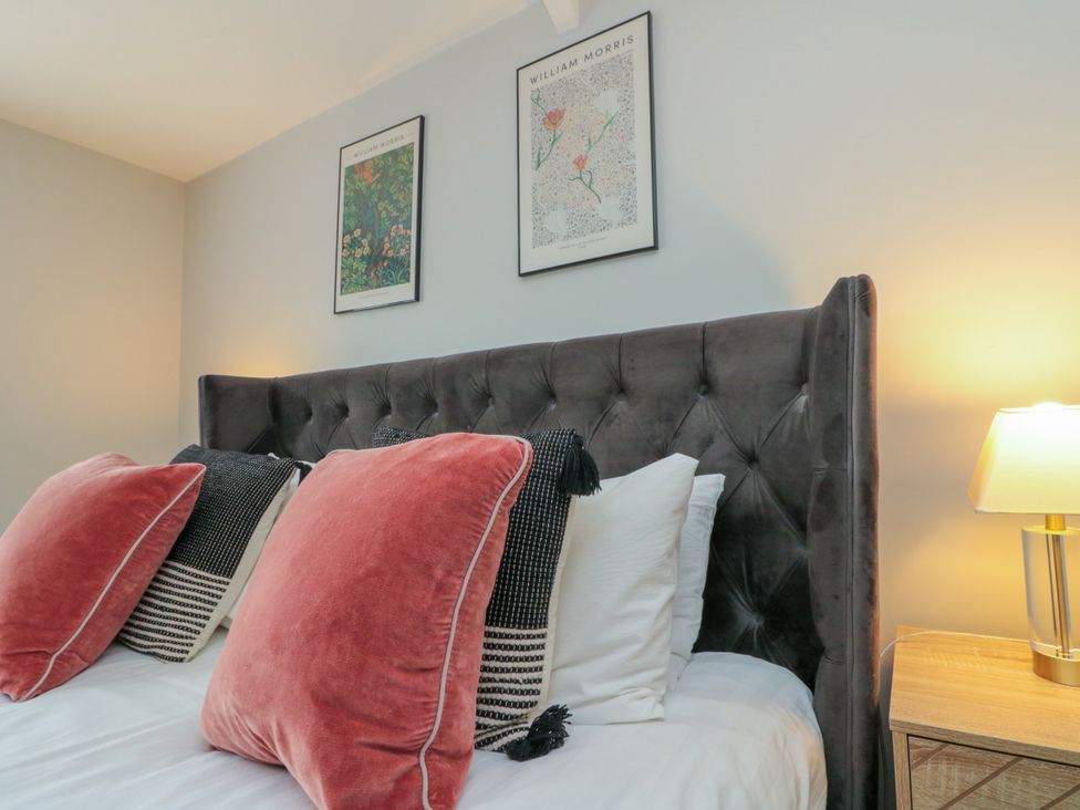 A bedroom with a bed and wall art at The Pheasantry in Flamborough