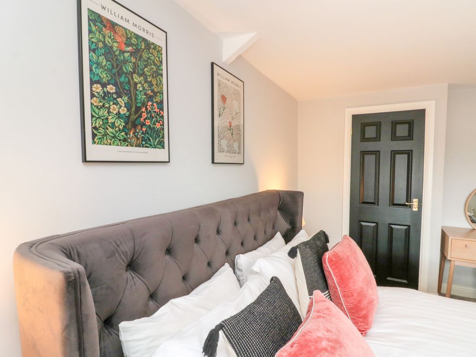 A bedroom with a bed and artwork on the wall at The Pheasantry in Flamborough