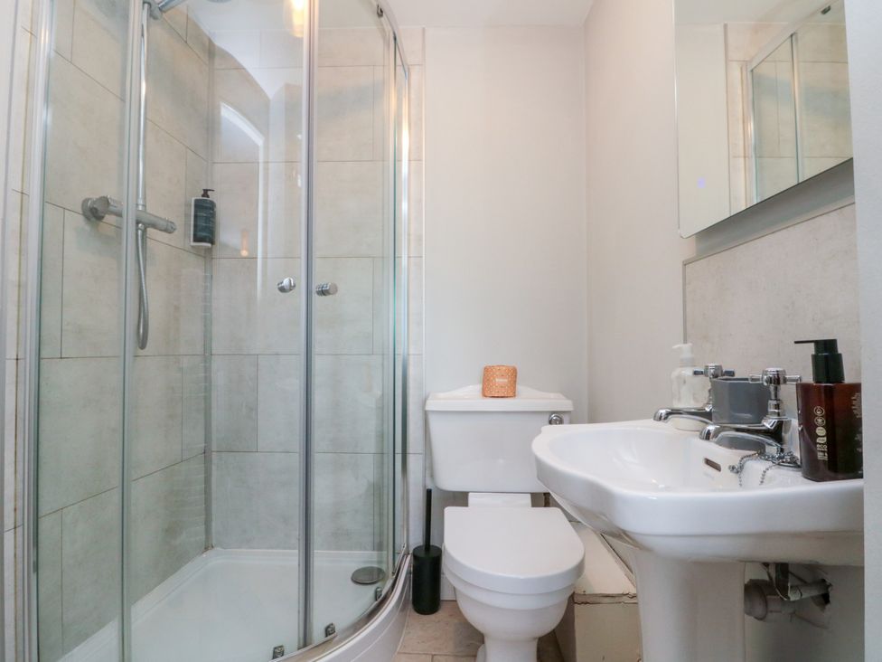 A bathroom with a shower, toilet, and sink at The Pheasantry in Flamborough