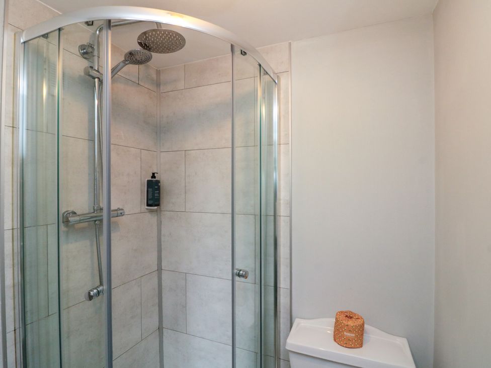 A shower enclosure with wall tiles and a soap dispenser at The Pheasantry in Flamborough