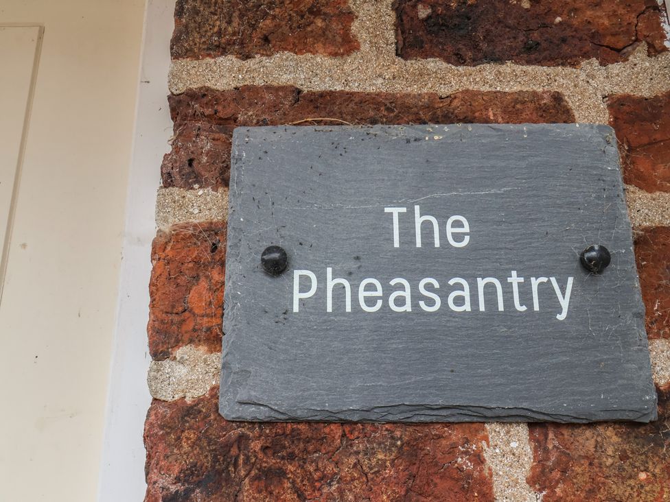 A sign displaying the name 'The Pheasantry' on a brick wall at The Pheasantry in Flamborough