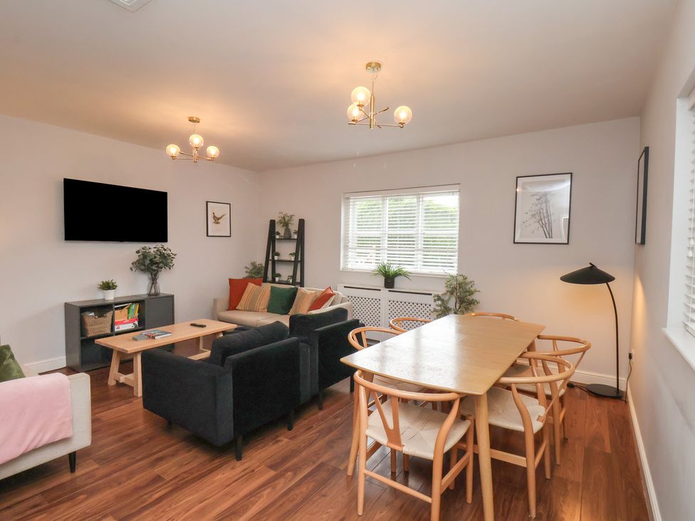 A living room with a television and dining table at The Pheasantry Flamborough