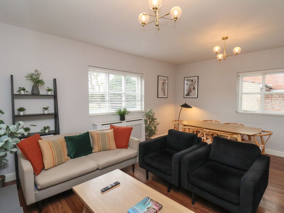 A living room with a sofa, armchairs and dining area at The Pheasantry in Flamborough
