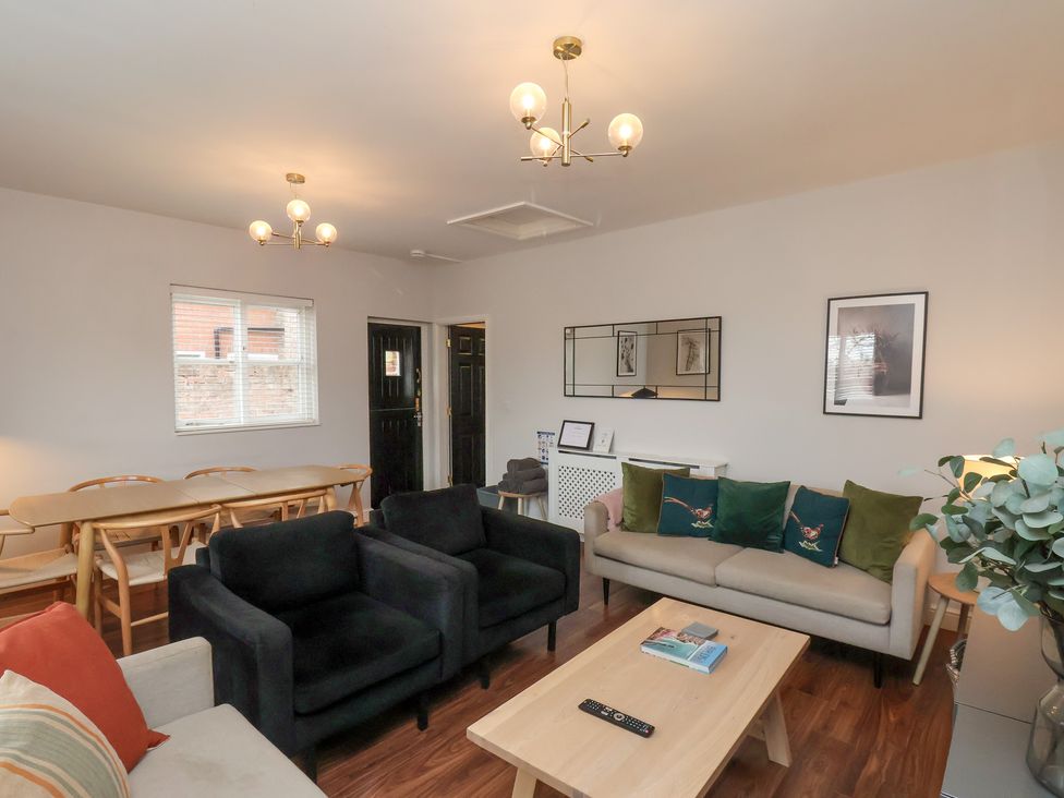 A living room with a dining table and chairs at The Pheasantry in Flamborough