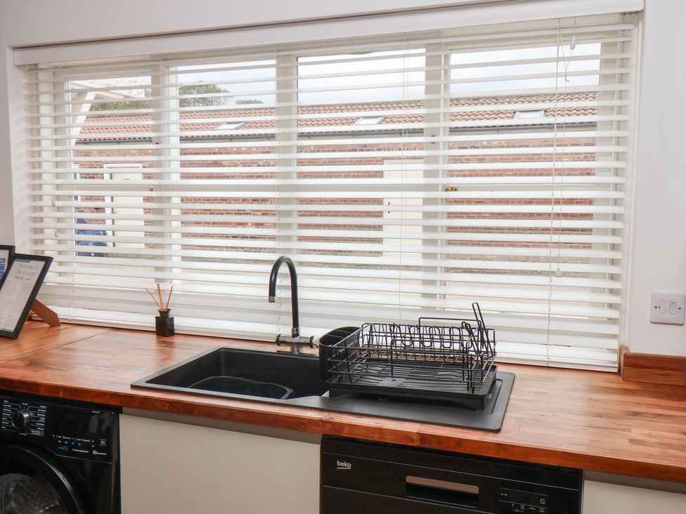 A kitchen with a sink and dish rack at The Pheasantry in Flamborough