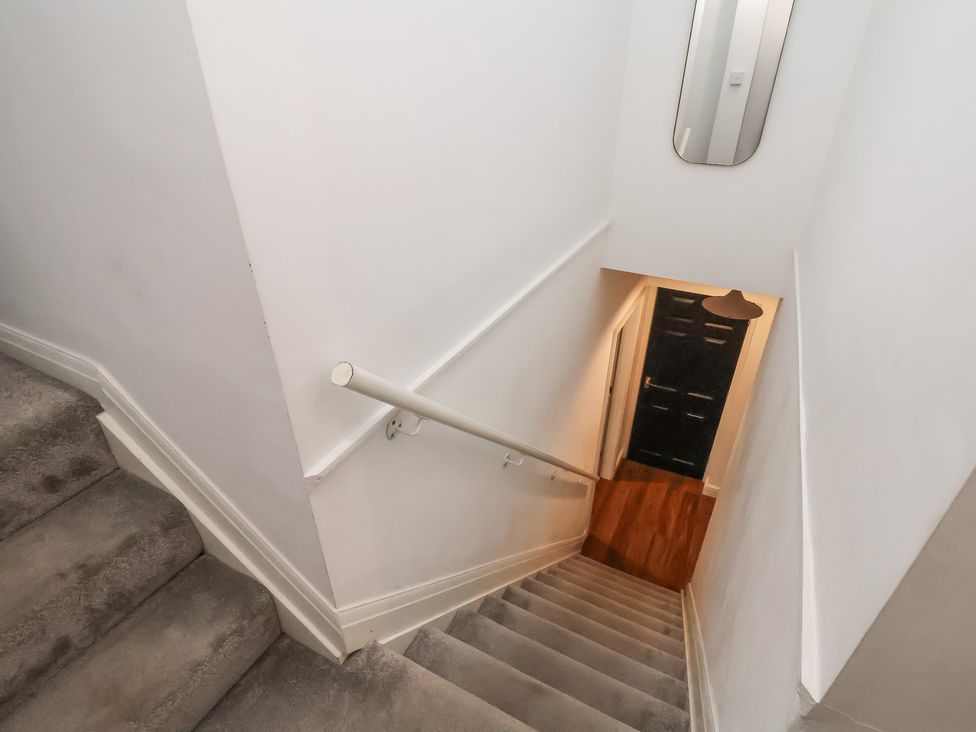 A staircase with a handrail and door at The Pheasantry in Flamborough