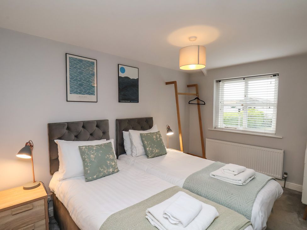 A bedroom with two beds and artwork on the walls at The Pheasantry in Flamborough