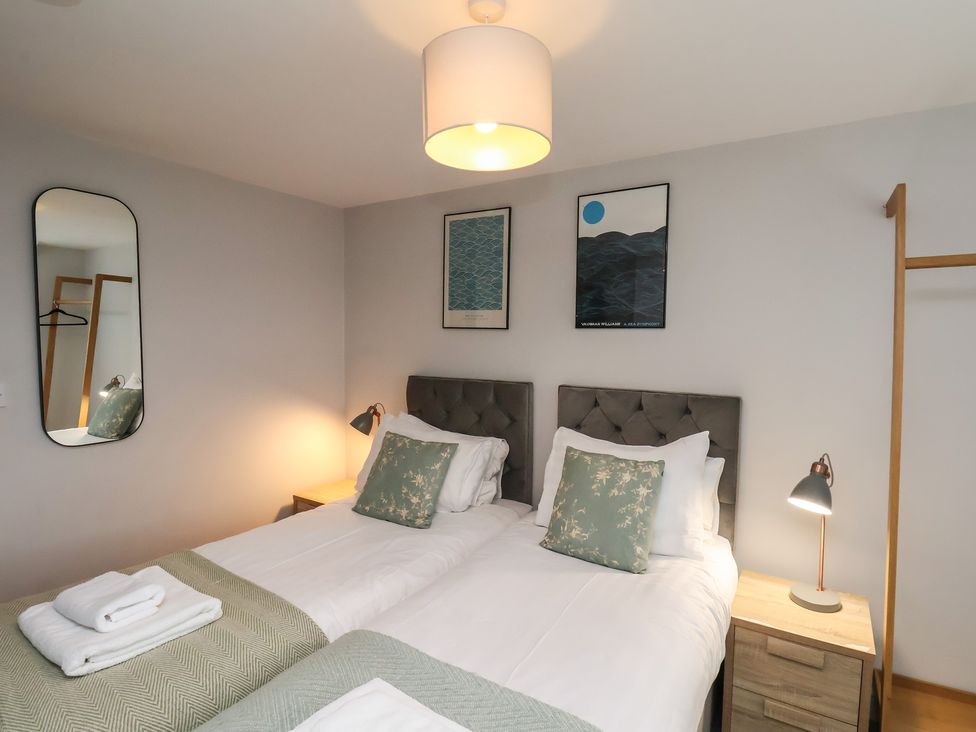 A bedroom with twin beds and wall art at The Pheasantry in Flamborough