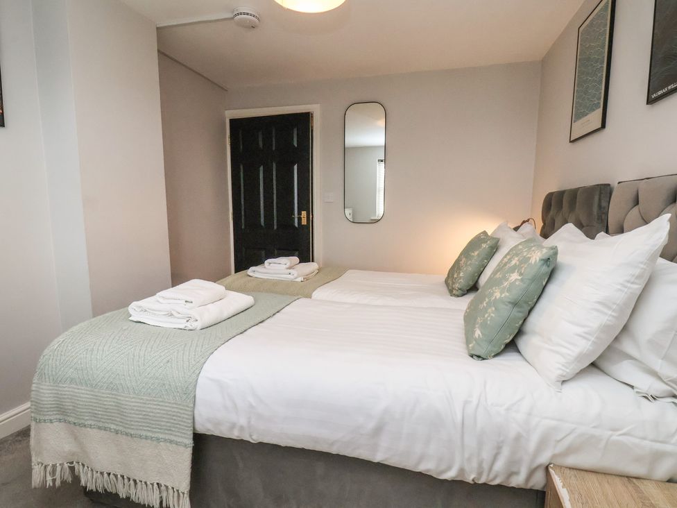 A bedroom with a bed and mirror at The Pheasantry in Flamborough