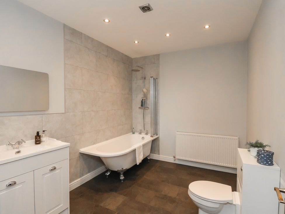 A bathroom with a bathtub, sink, toilet and shower at The Pheasantry in Flamborough
