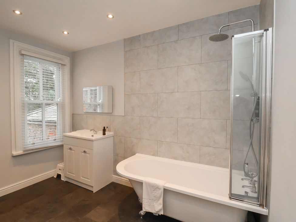A bathroom featuring a bathtub, shower, sink, and window at The Pheasantry in Flamborough