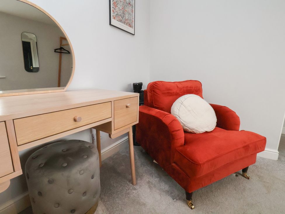 A chair and vanity with a mirror in a bedroom at The Pheasantry in Flamborough