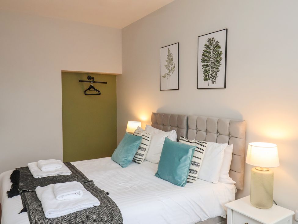 A bedroom with a bed and two lamps at The Pheasantry in Flamborough