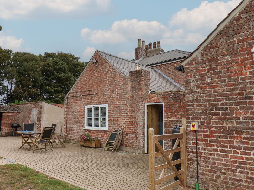 An outdoor area with brick walls and furniture at The Pheasantry in Flamborough