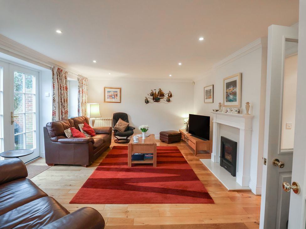 A living room with a sofa, table, and television at 9 Church Farm Rise, Aldeburgh