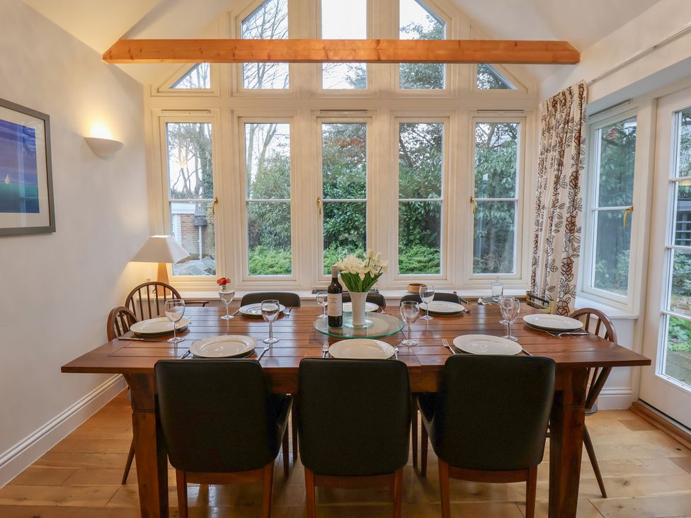 A dining room with a table set for dinner at 9 Church Farm Rise in Aldeburgh