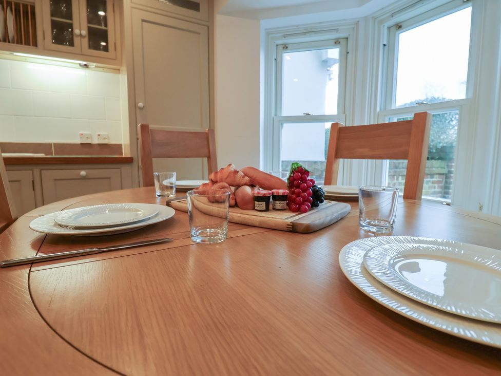 A dining room with a table set for a meal at 9 Church Farm Rise Aldeburgh