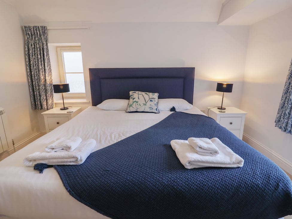 A bedroom with a bed and nightstands at 9 Church Farm Rise Aldeburgh