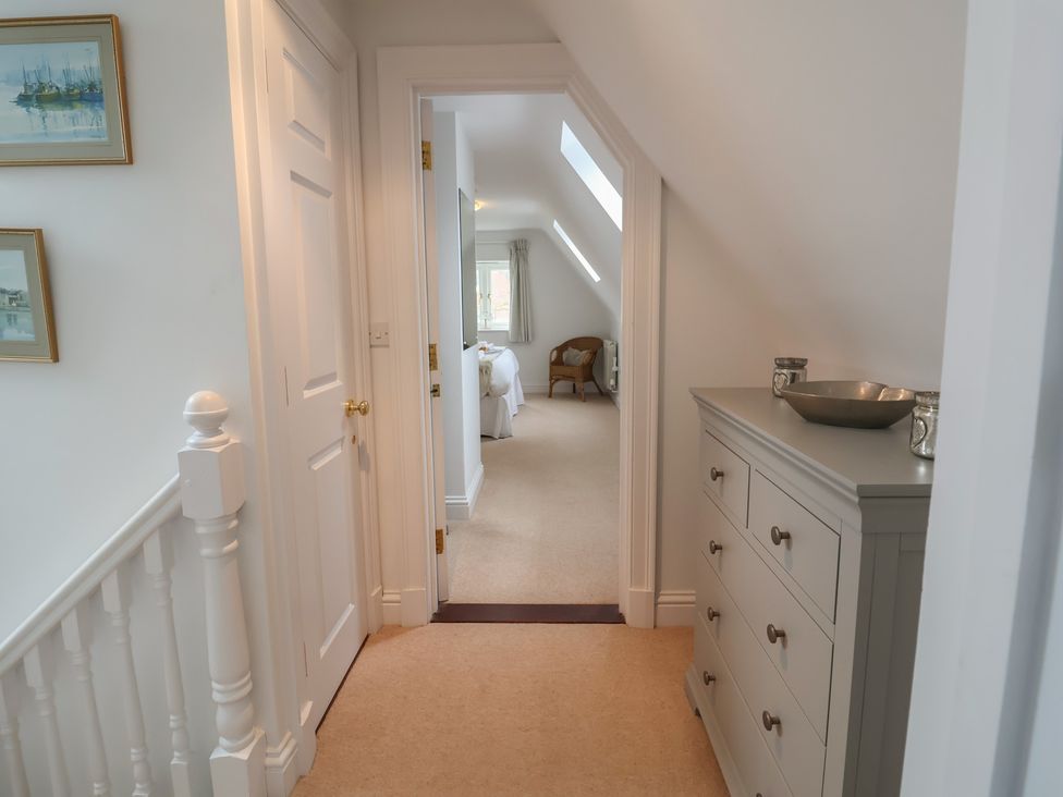 A hallway with a dresser and paintings at 9 Church Farm Rise in Aldeburgh