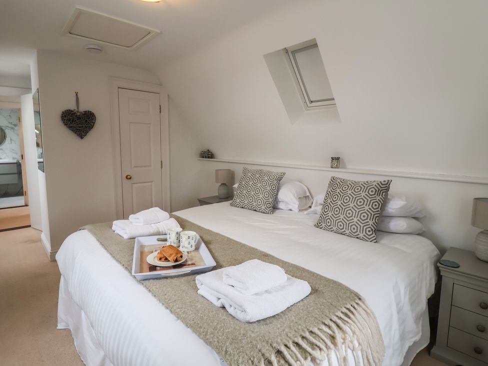 A bedroom with a double bed and side table at 9 Church Farm Rise Aldeburgh