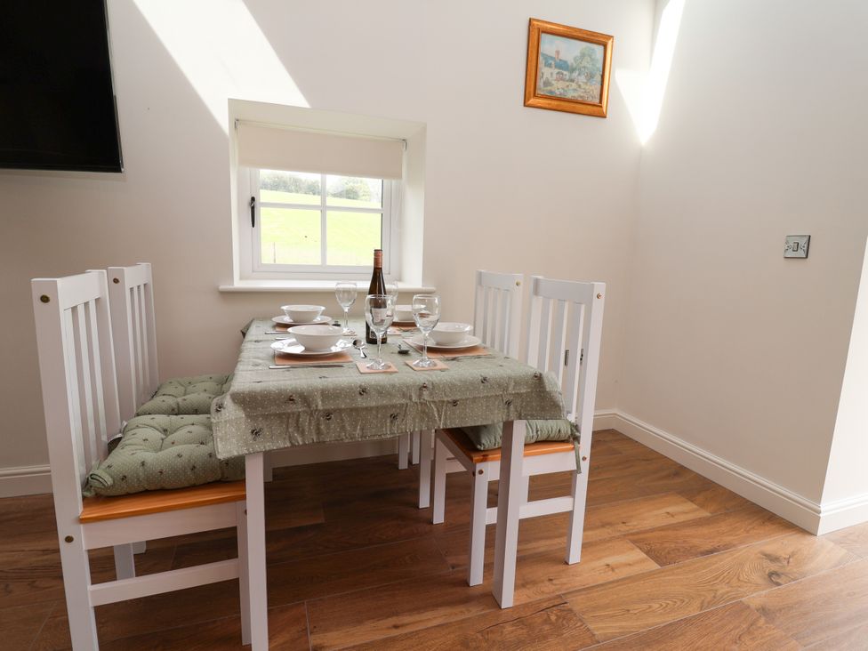 A dining room with a table and chairs at The Barn in Tafarn-Y-Gelyn