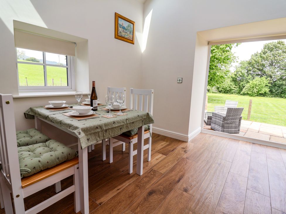A dining room with a table and chairs at The Barn in Tafarn-Y-Gelyn