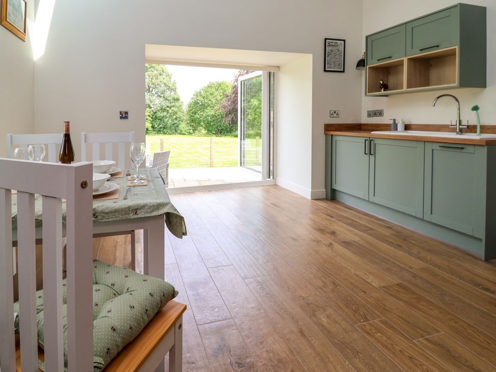 A dining room with a table and chairs at The Barn in Tafarn-Y-Gelyn